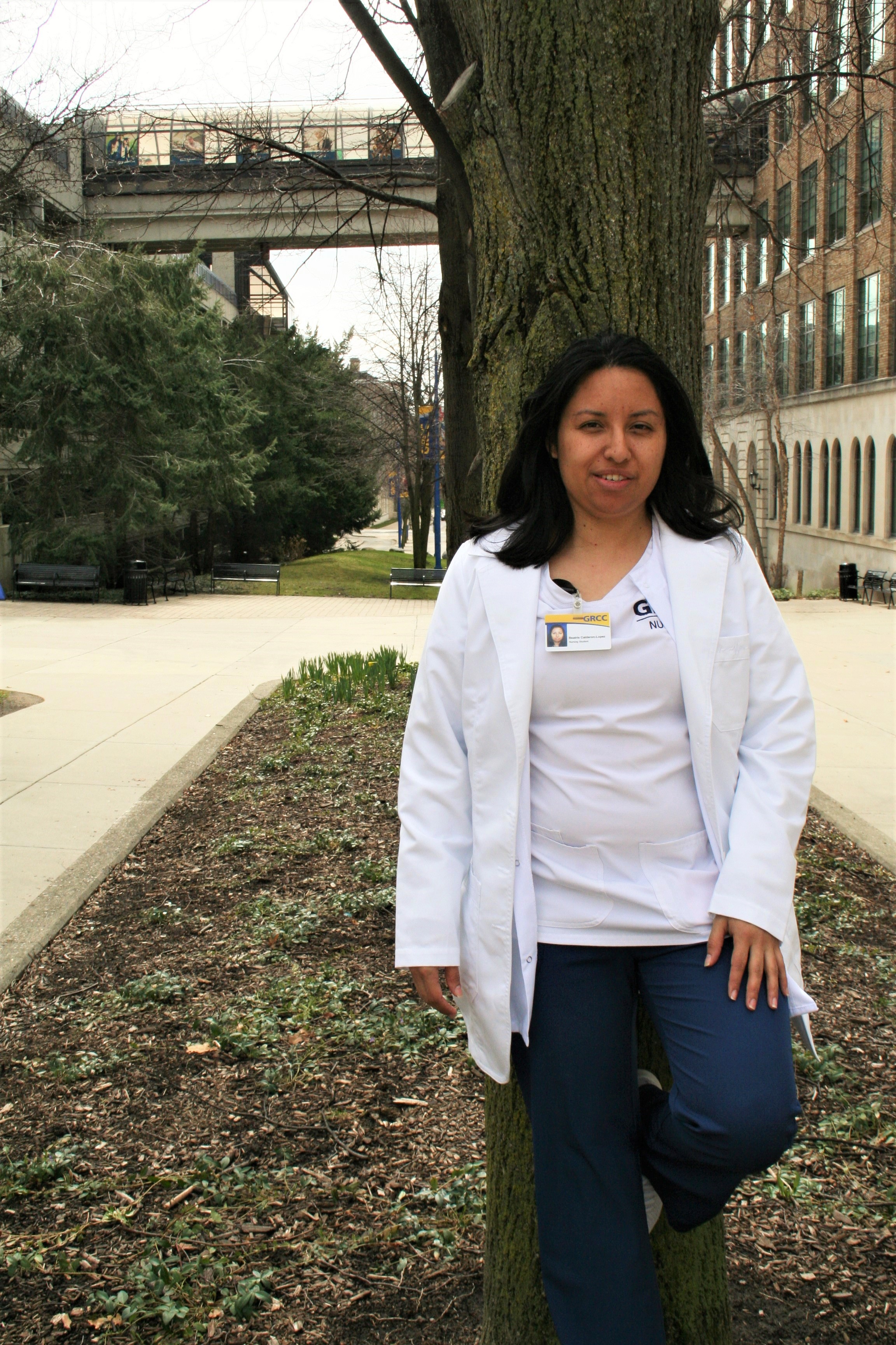 Beatris outside on the commons leaning against a tree