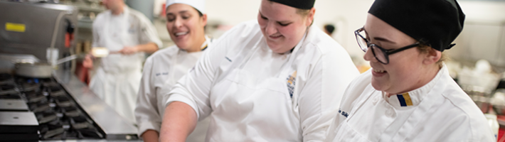Culinary students cooking in the kitchen.