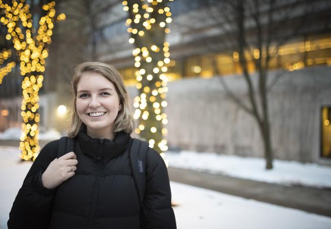Student outside in the holiday lights