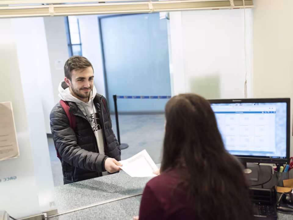 Student paying a bill at the cashier window