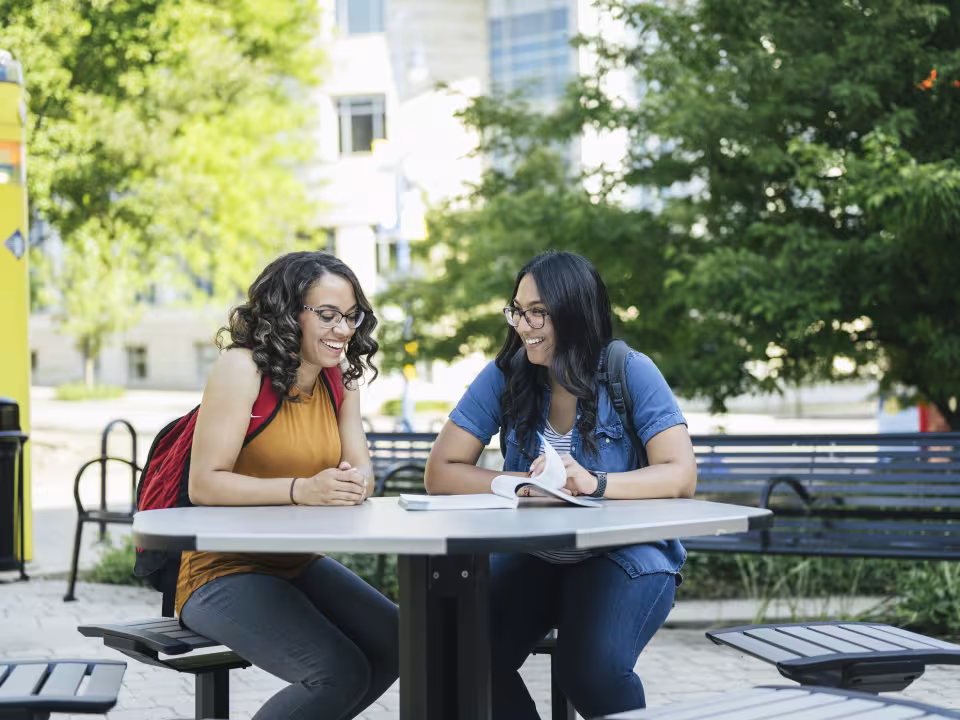 Students doing homework together outside of RJF on a summer day.