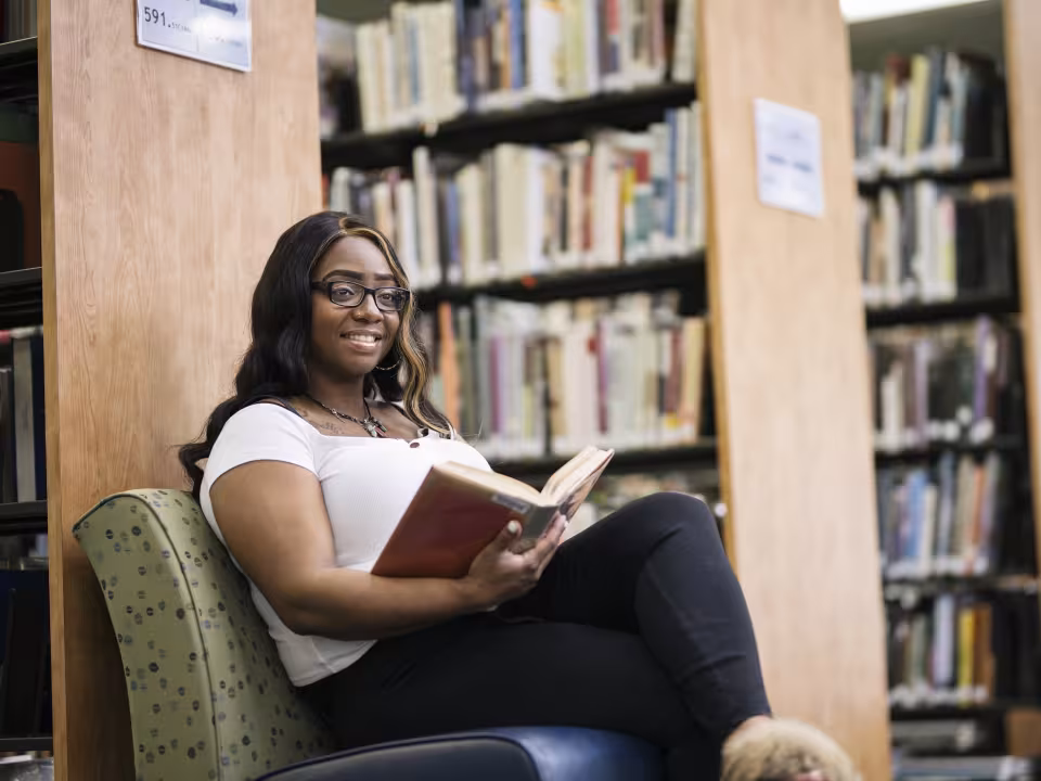 Student reading a book in the library