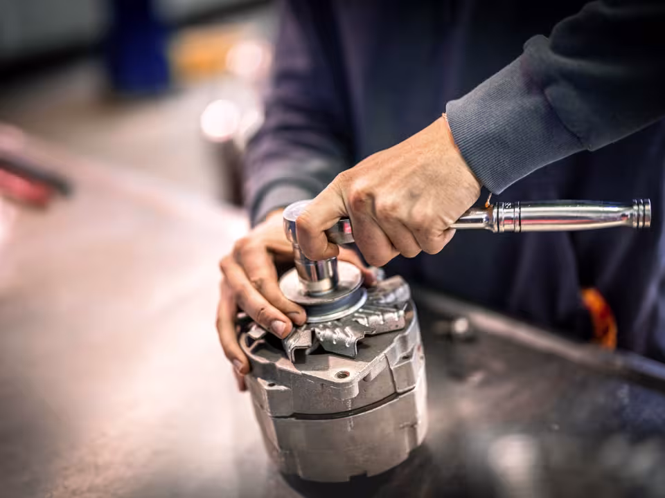 Student working on car part with a socket wrench