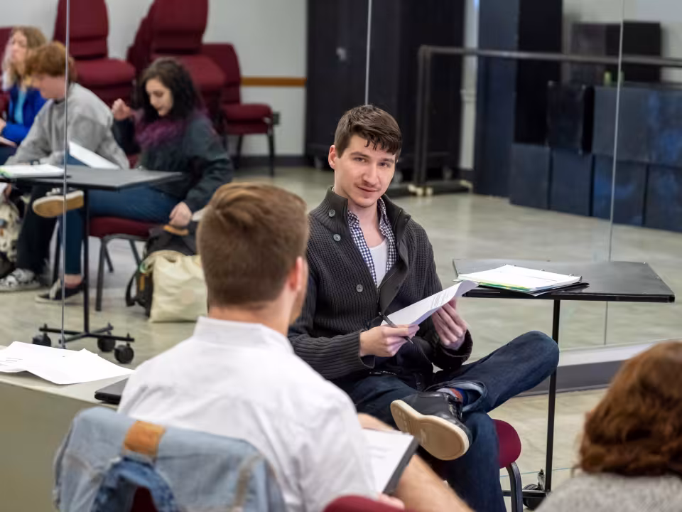 Student reading a script in a theater class