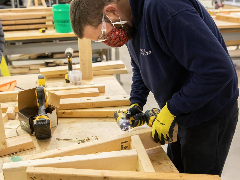 Public works student using a drill