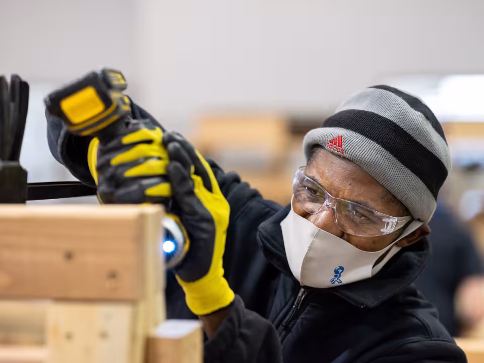 Public works student using a drill