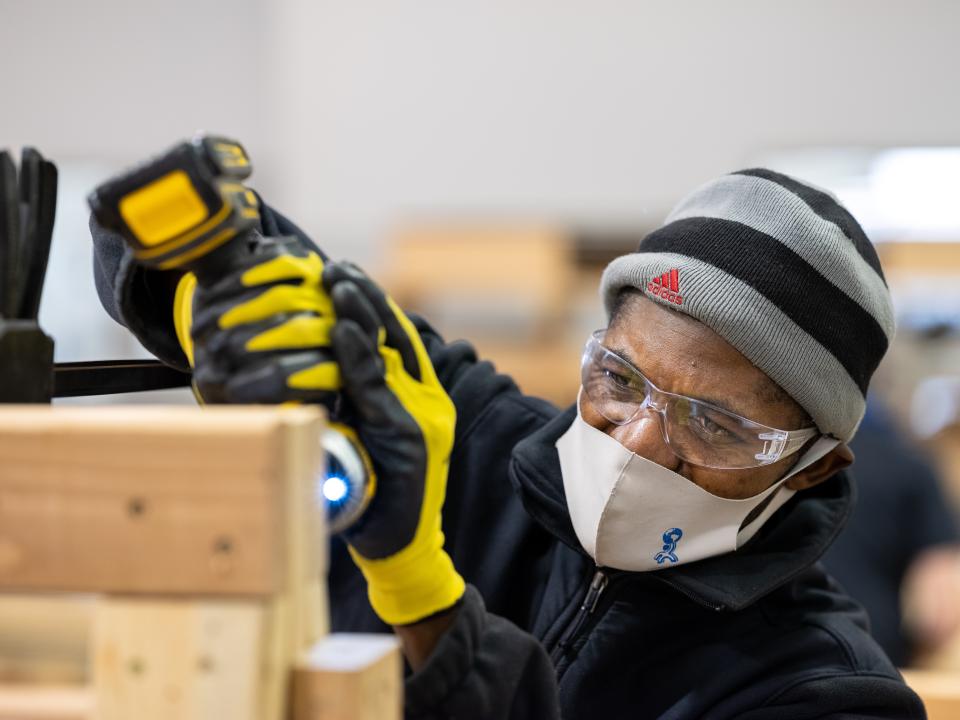 Public works student using a drill
