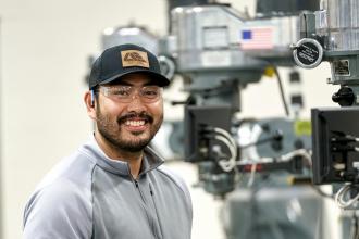 Производственный студент работает в лаборатории машин». ширина=