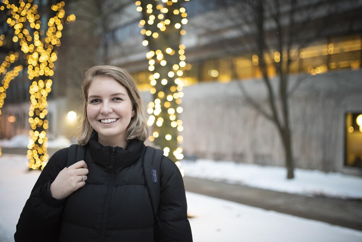 Student outside in the holiday lights