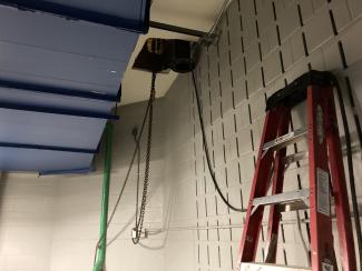 Chains and cables run into a hole in the ceiling.