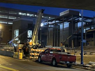 A construction crew works on an exterior in the dark.