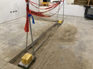 Electrical wiring in a space cut into a concrete floor.