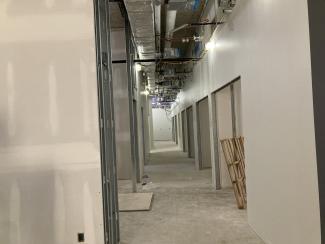 An unfinished hallway with duct work.