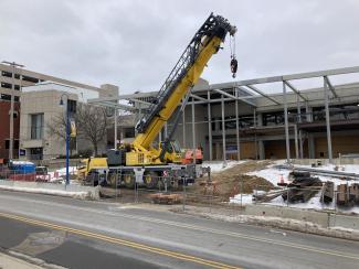 A large crane lifts steel beams.