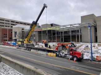 Cranes and heavy equipment near the street near the construction site.