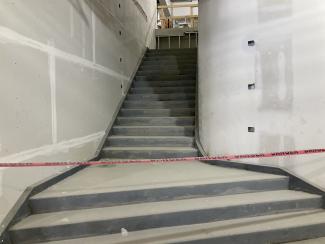 A stairway with unfinished drywall.