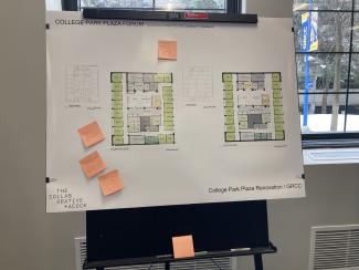 A design board of floor layouts with handwritten sticky notes stuck to it.