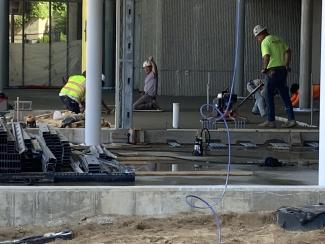 The concrete crew smoothing out the recently poured concrete