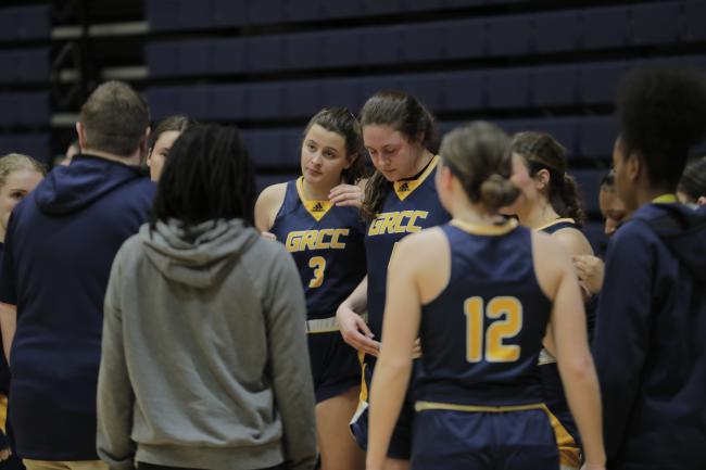 Basketball players listening to Coach Glazier.