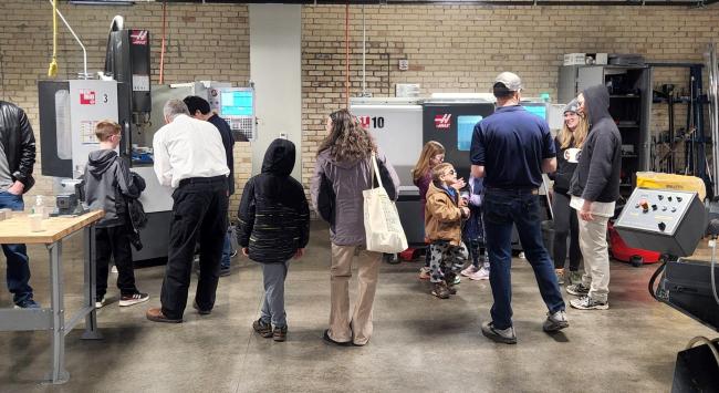 Families looking at manufacturing equipment at the 2022 event.