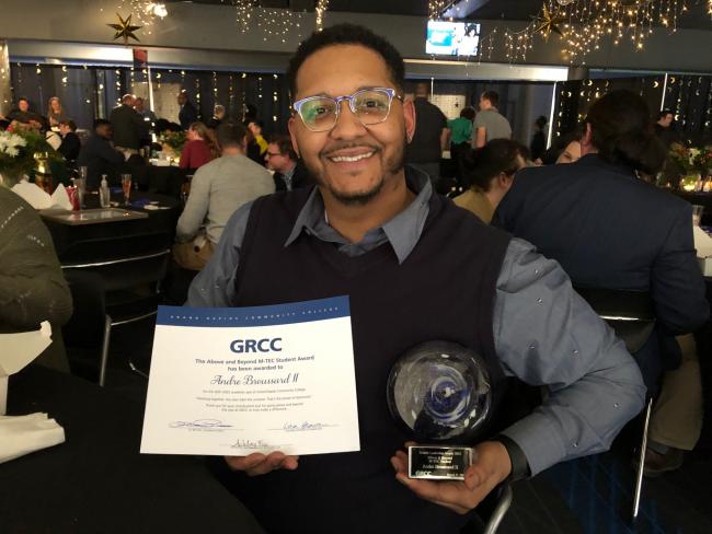 Andrew Broussard holding his awards.