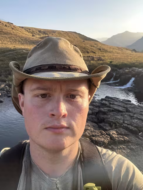 GRCC student Andrew Balcer pictured outdoors wearing a hat during his travels.