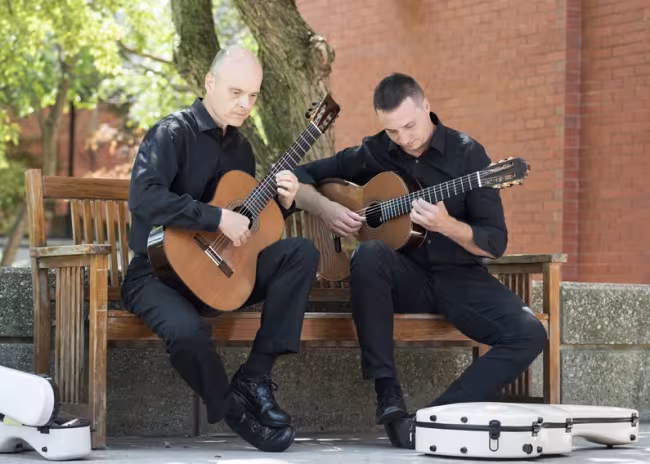 GRCC guitar instructors Brian Morris and Jonathan Marshall practicing outside.