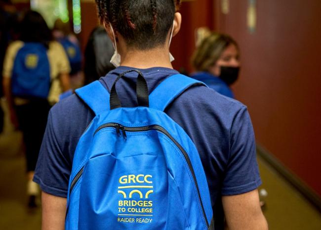 A Bridges to College student showing off his backpack.