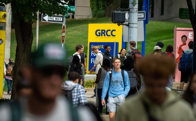 Students at GRCC cross the street in a crowd.