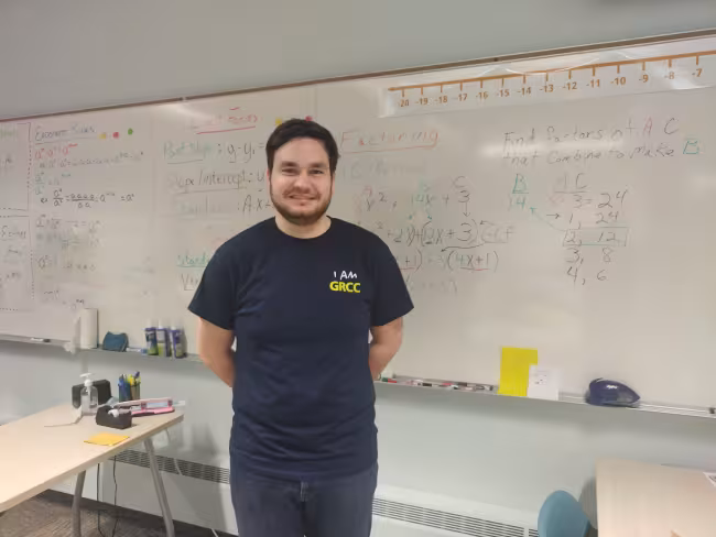 GRCC math instructor Chance Colter stands in front a white board in a classroom.