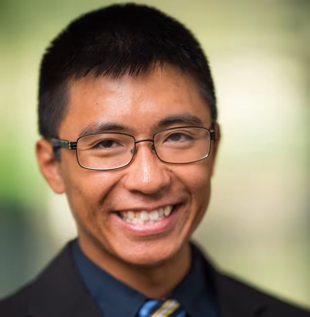 Headshot of Don Hua, wearing a suit and tie.