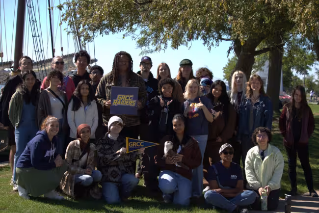 A group of GRCC students with a tall sailing ship in the background.