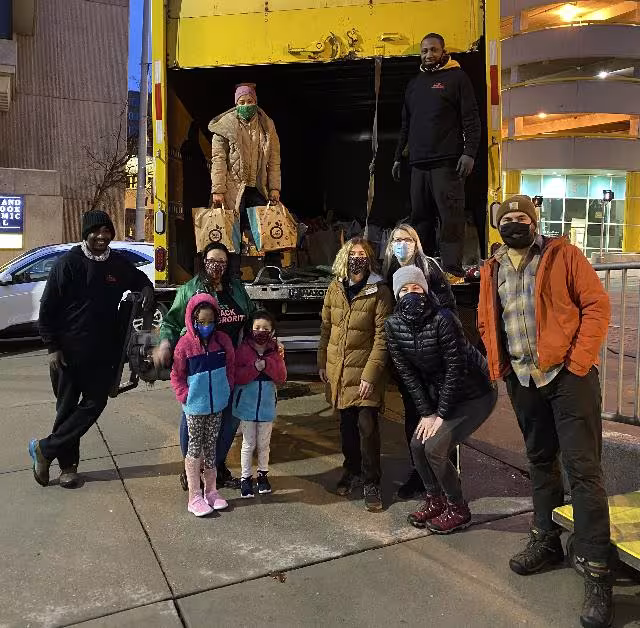 Students and staff standing by a delivery truck