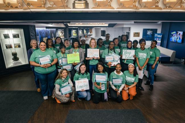 Mentors at the G3 Conference hold up signs with encouraging messages for students.
