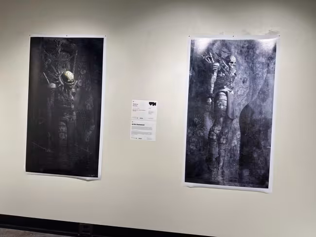 Two artpieces depicting skeletons in armor hang on a wall. 