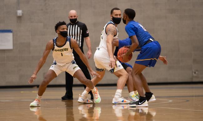 GRCC basketball players playing defense in a game.