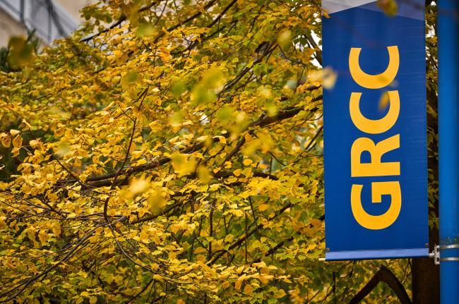 Autumn leaves in front of a GRCC banner on campus.