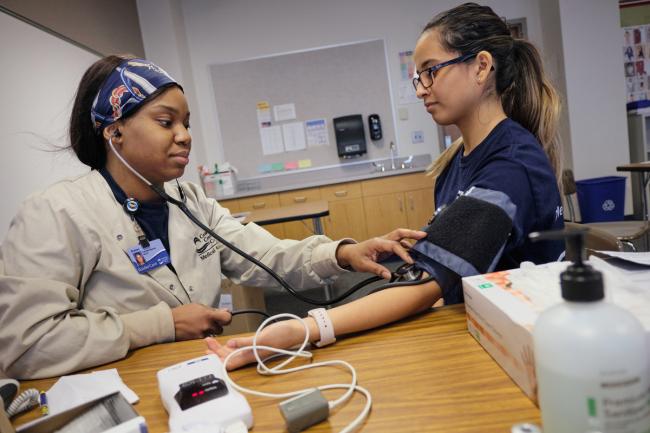 Students in the Medical Assistant program training to check blood pressure.