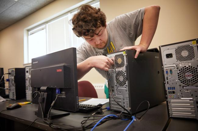 GRCC student working to repair a computer in a Job Training class
