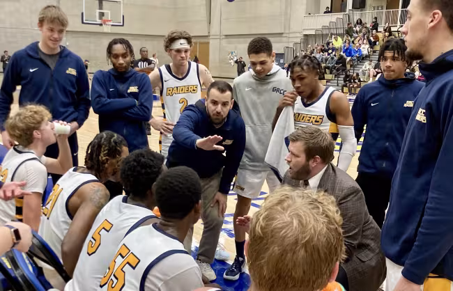 Islam Hoxha talking to the basketball team during a timeout.