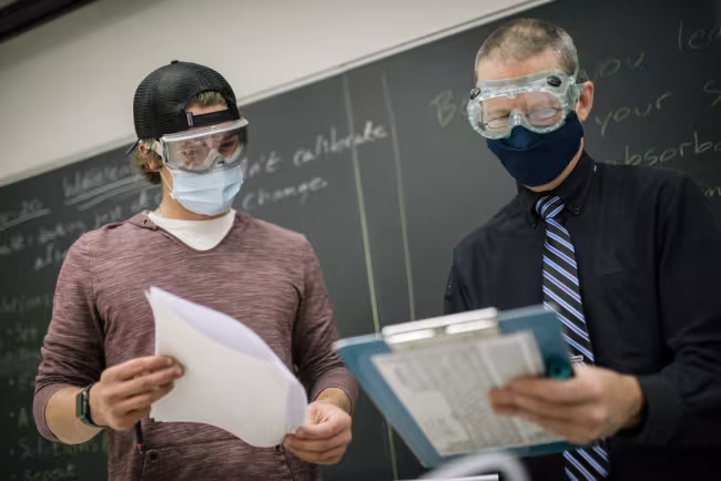 A student and professor in a Chemistry class.
