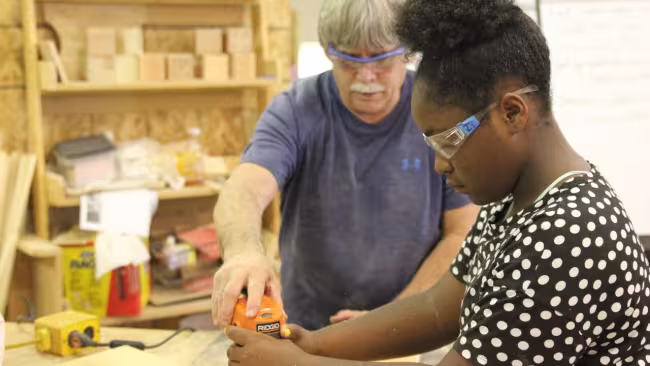 Instructor Steve Ray working with a student in woodworking camp.