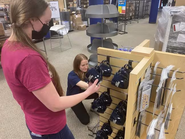 Bookstore employees stocking displays. 