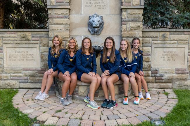 Kaylee Scott and other members of the cross country team sit at the iconic lion fountain. 