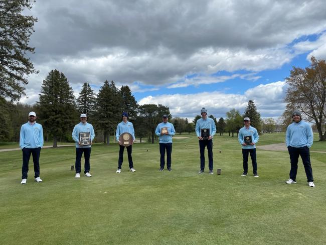 Golf team members posing with their trophies.