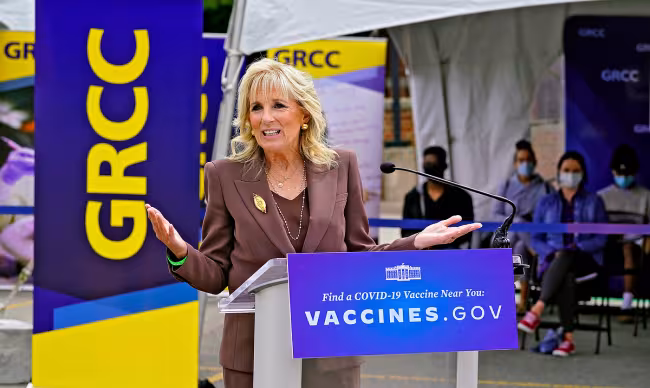 First Lady Jill Biden speaking at a podium after touring GRCC's pop-up clinic.