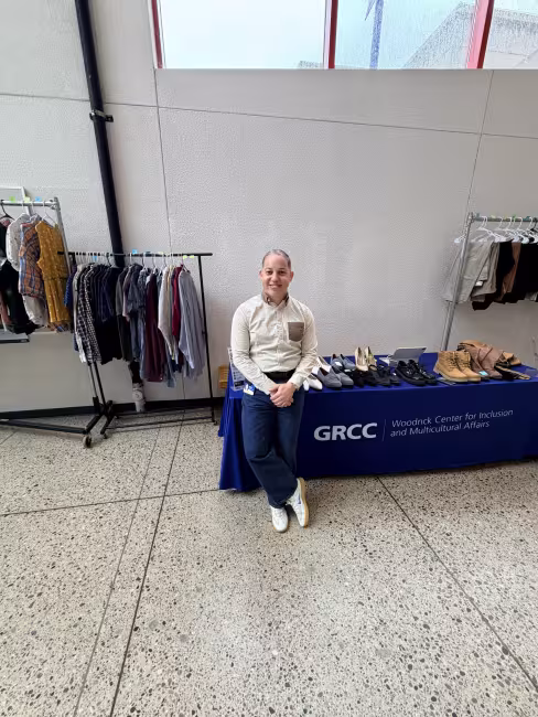 Joel Reyes Hernandez stands beside the student clothing pop-up.