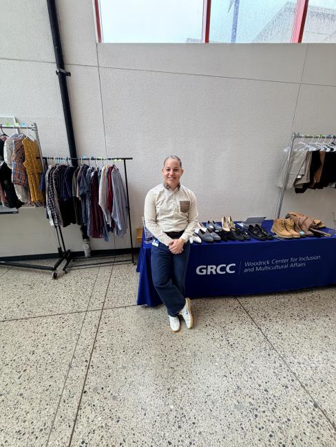 Joel Reyes Hernandez stands beside the student clothing pop-up.