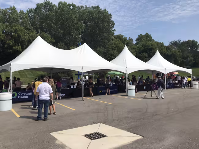 Job seekers talk with health care employers during an outdoor event.