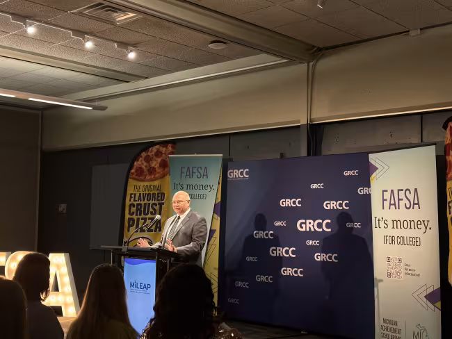 GRCC President Charles W. Lepper stands at a podium in front of a GRCC backdrop.